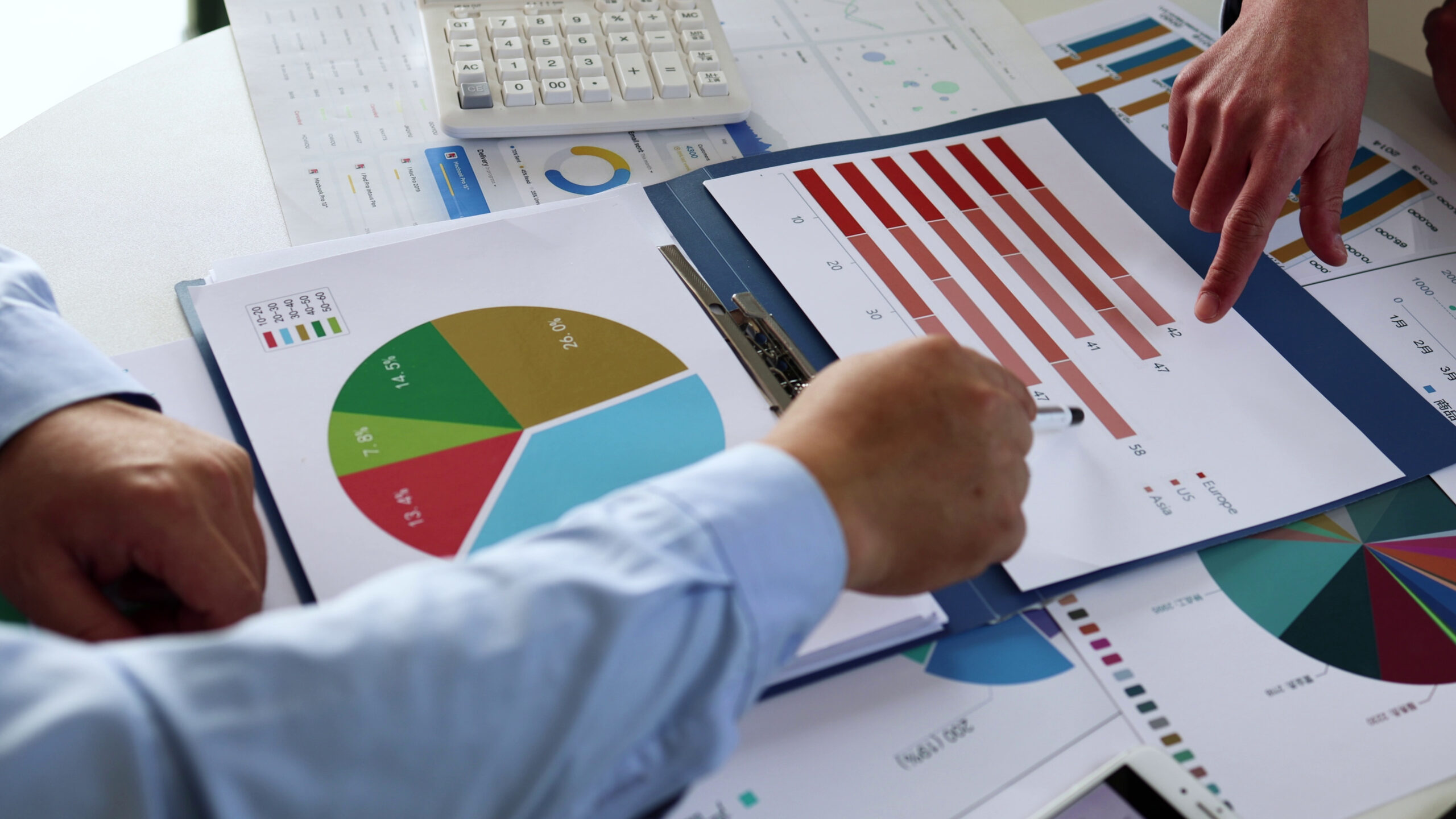 Financial advisors reviewing investment charts, portfolio allocation reports, and market analysis data